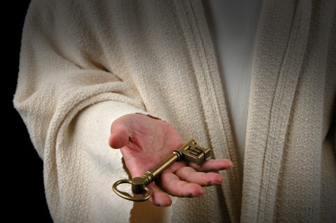 Hands of Jesus offering key of the Kingdom of Heaven